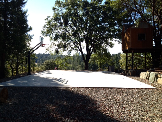 On the left there is a Pro Dunk Gold Basketball System on the concrete slab half court.