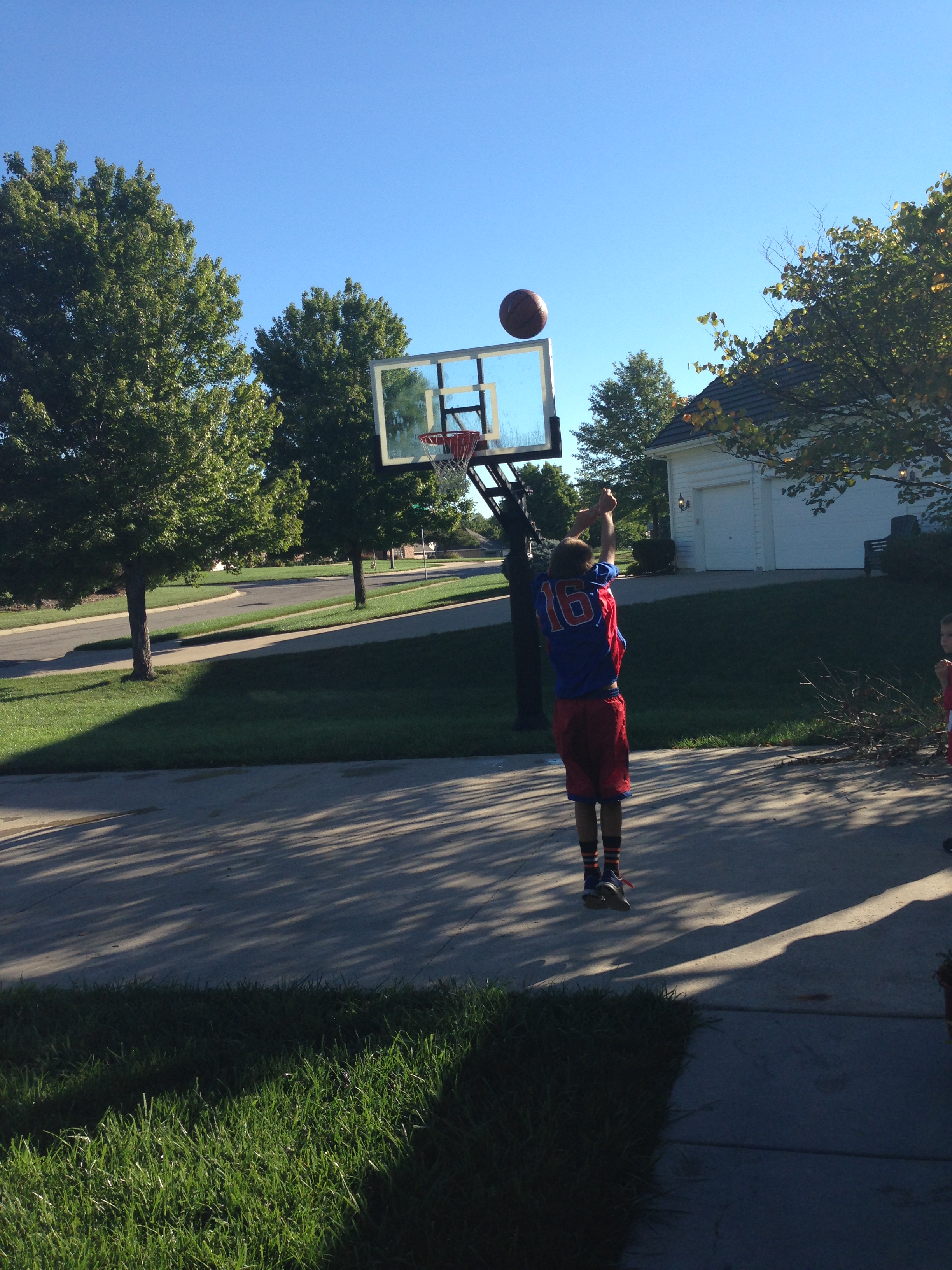 The trees around this Kansas home offer shade for the practice area of this Pro Dunk Gold Basketball system. 