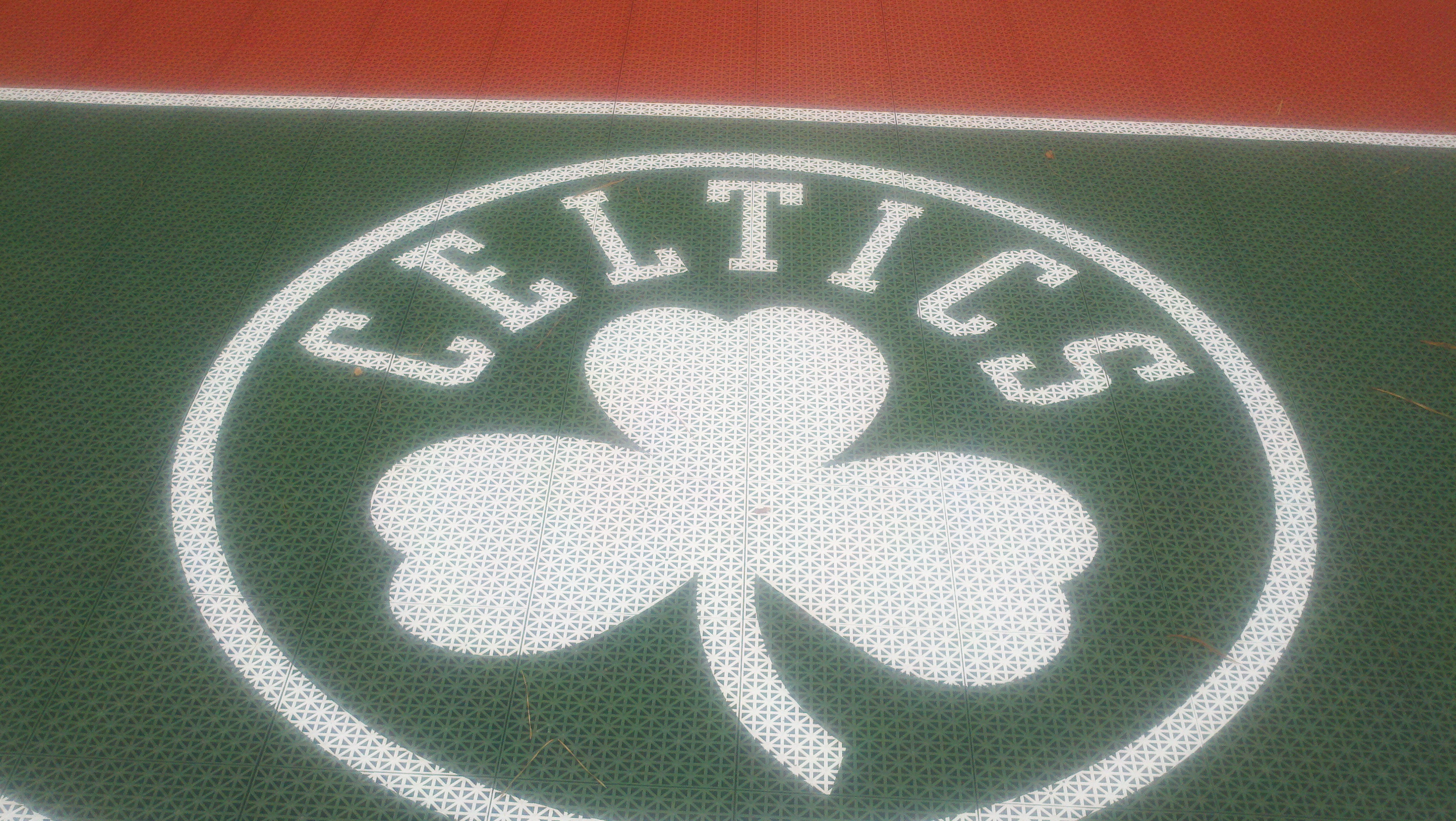 The painted Boston Celtics logo looks sharp on Burce's court surfacing.