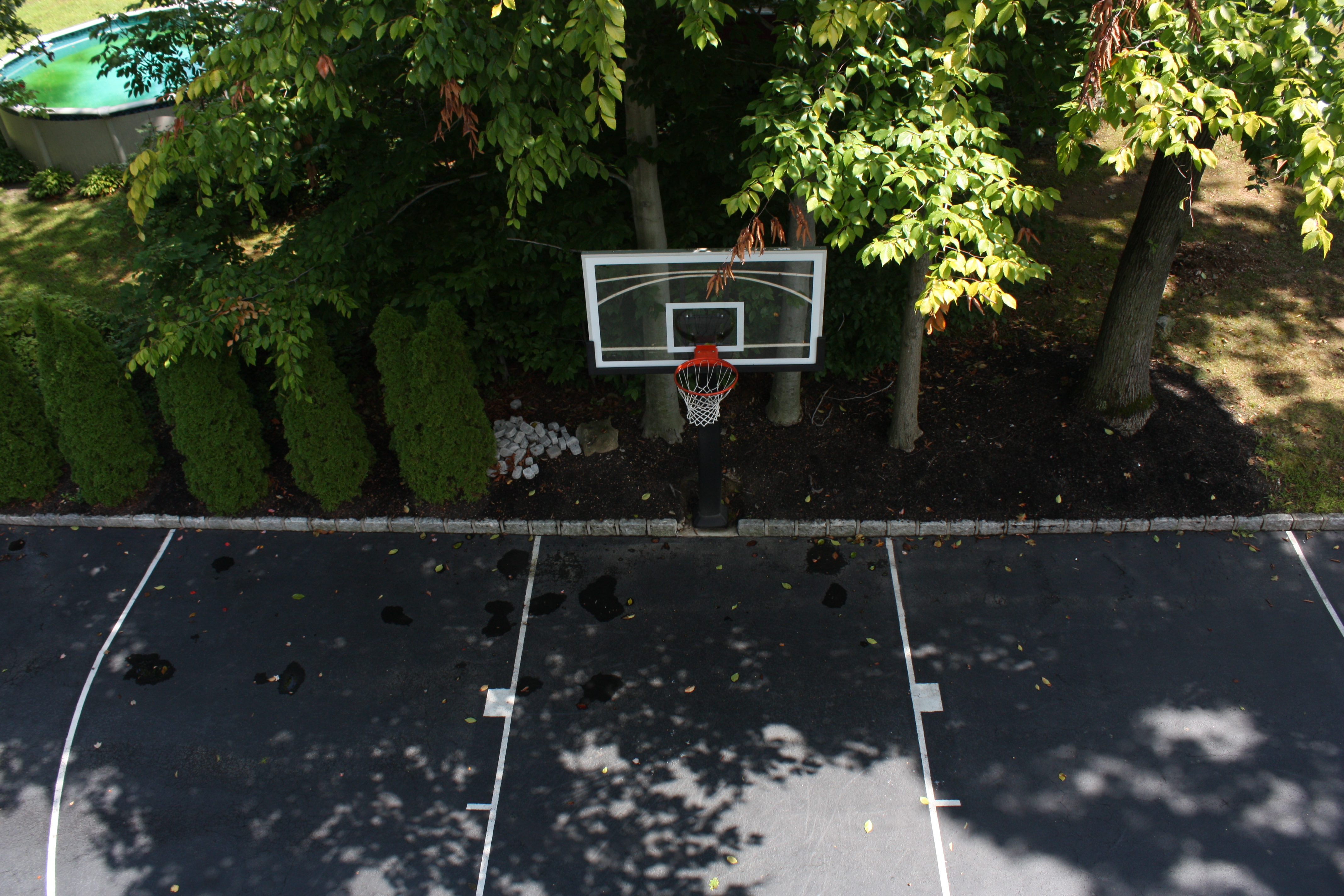 A very unique perspective on this parking lot basketball court.  The Pro Dunk Platinum basketball system sits right behind a line of pavers adding a nice trim to the asphalt court.