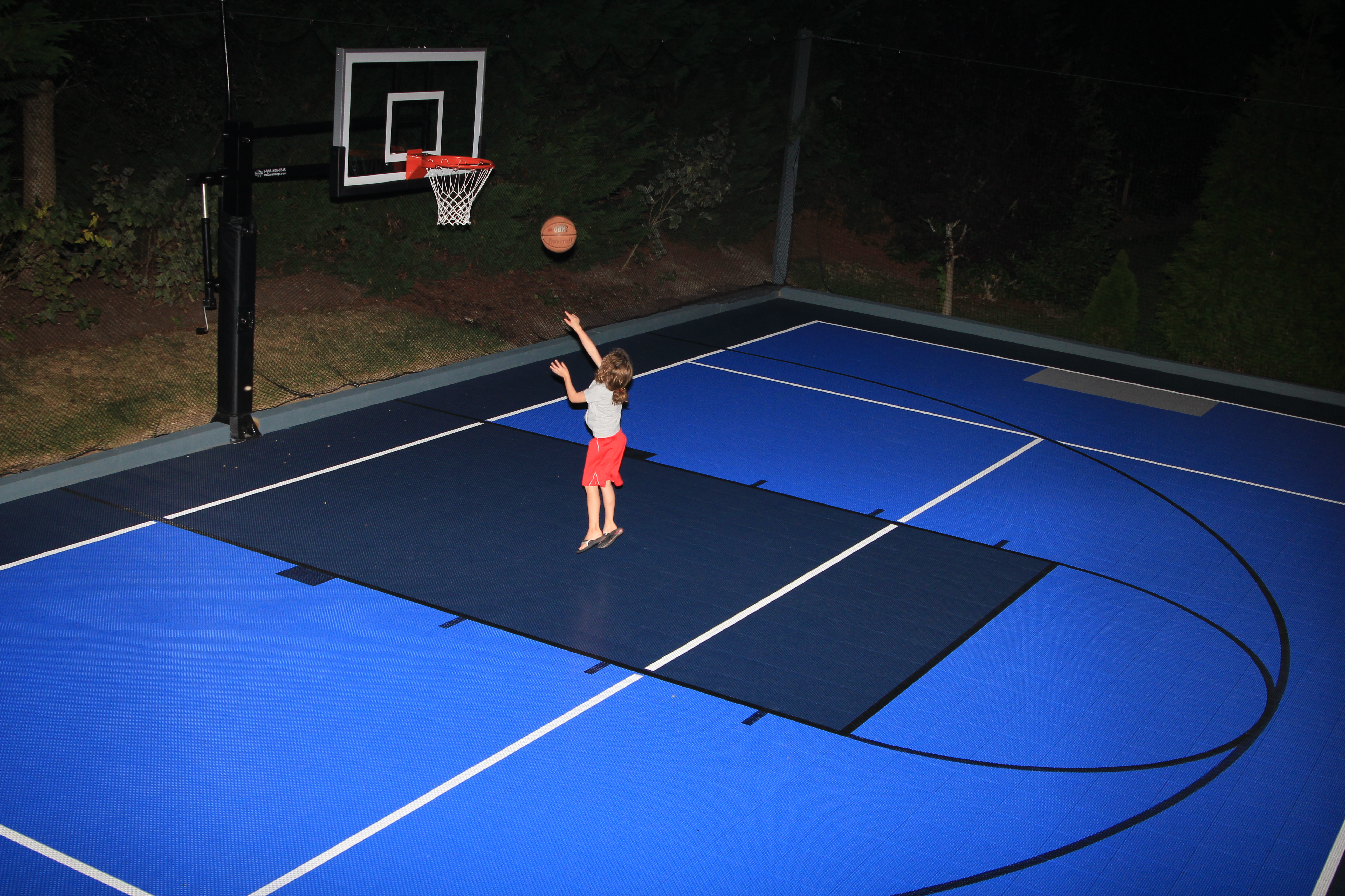 There is an aerial view of a girl shooting at a Pro Dunk Basketball System.