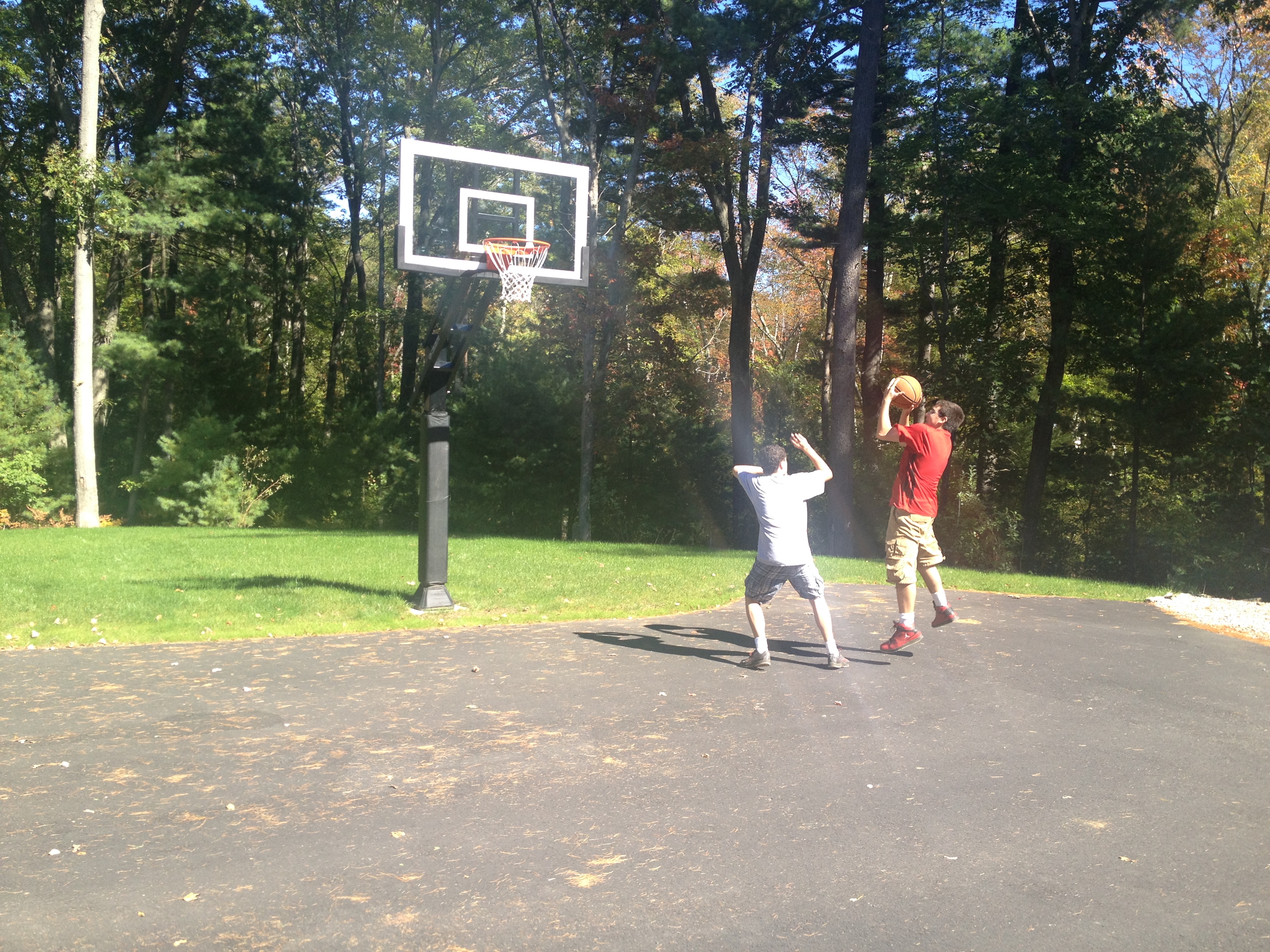 On the right there is a young boy attempting to make his shot at the basket.
