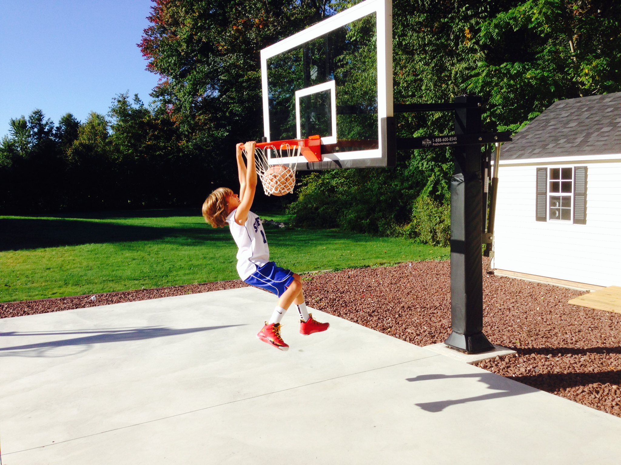 An awesome dunk at the basket by a young boy!