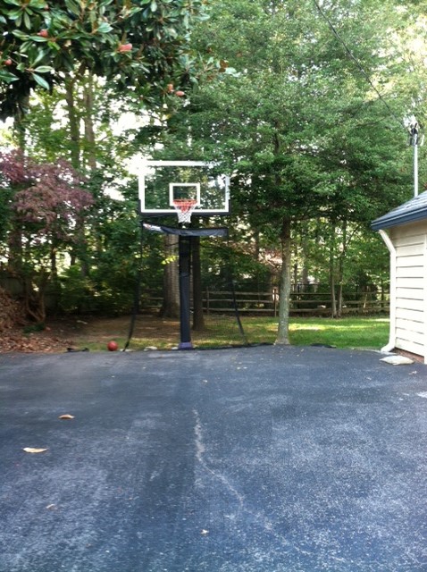 This front view shows a Pro Dunk Platinum Basketball system installed with a sloped net to catch and return shots.