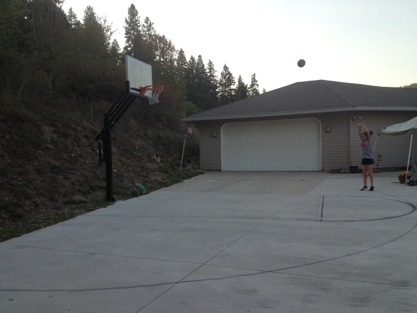 Kelly's daughter attempts a three pointer from the house side of the court.