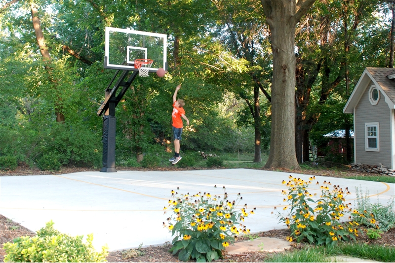 A young boy makes a layup on his Pro Dunk Diamond basketball goal. 