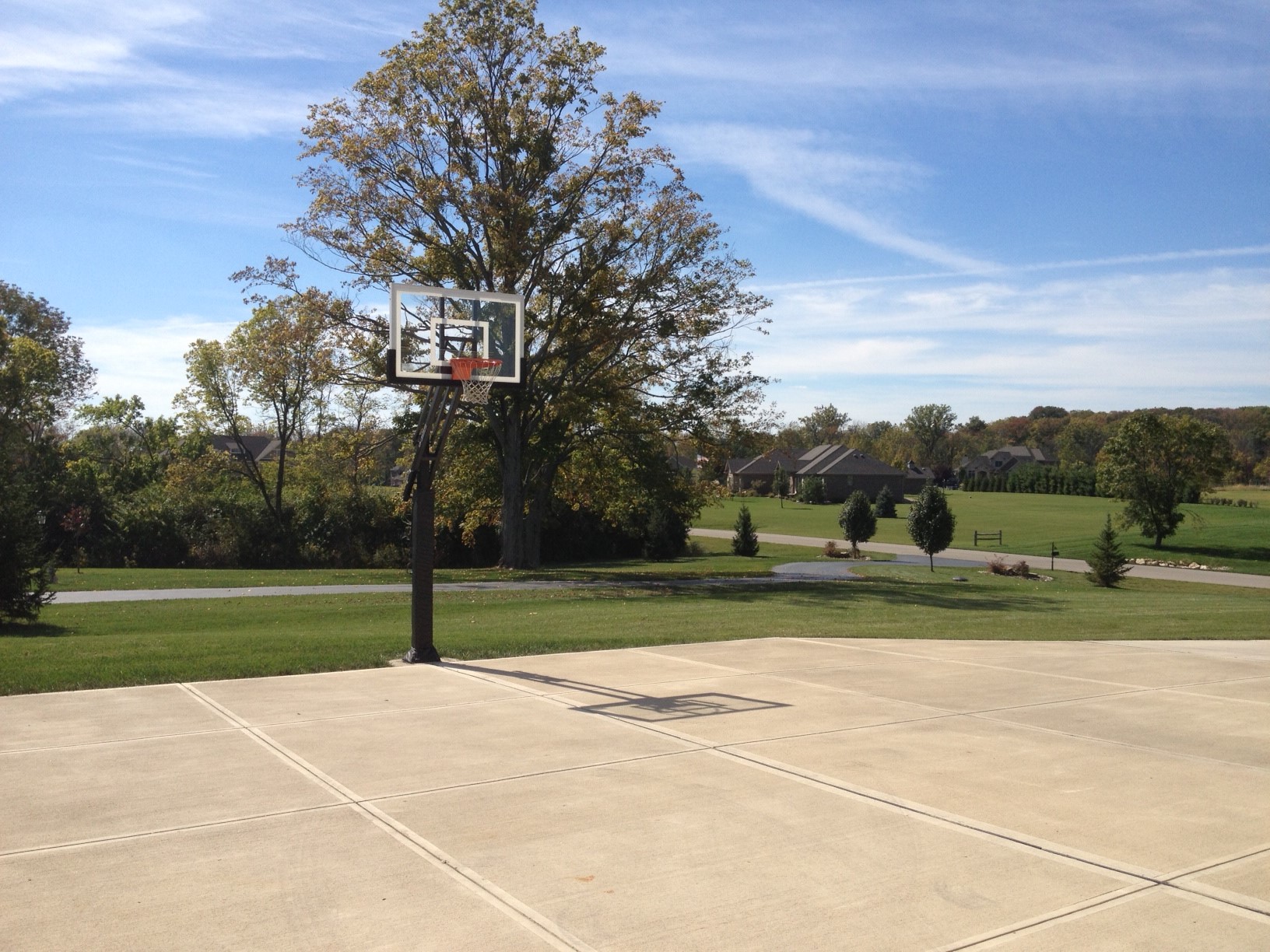 There is a Pro Dunk Silver Basketball System that is assembled perfectly on the side of their large concrete driveway. 