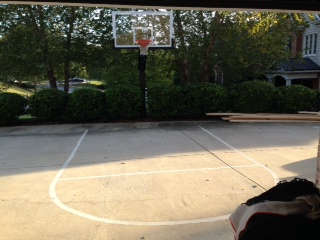 There is a Pro Dunk Platinum Basketball System that sits nicely beside the striped basketball court on the concrete driveway.