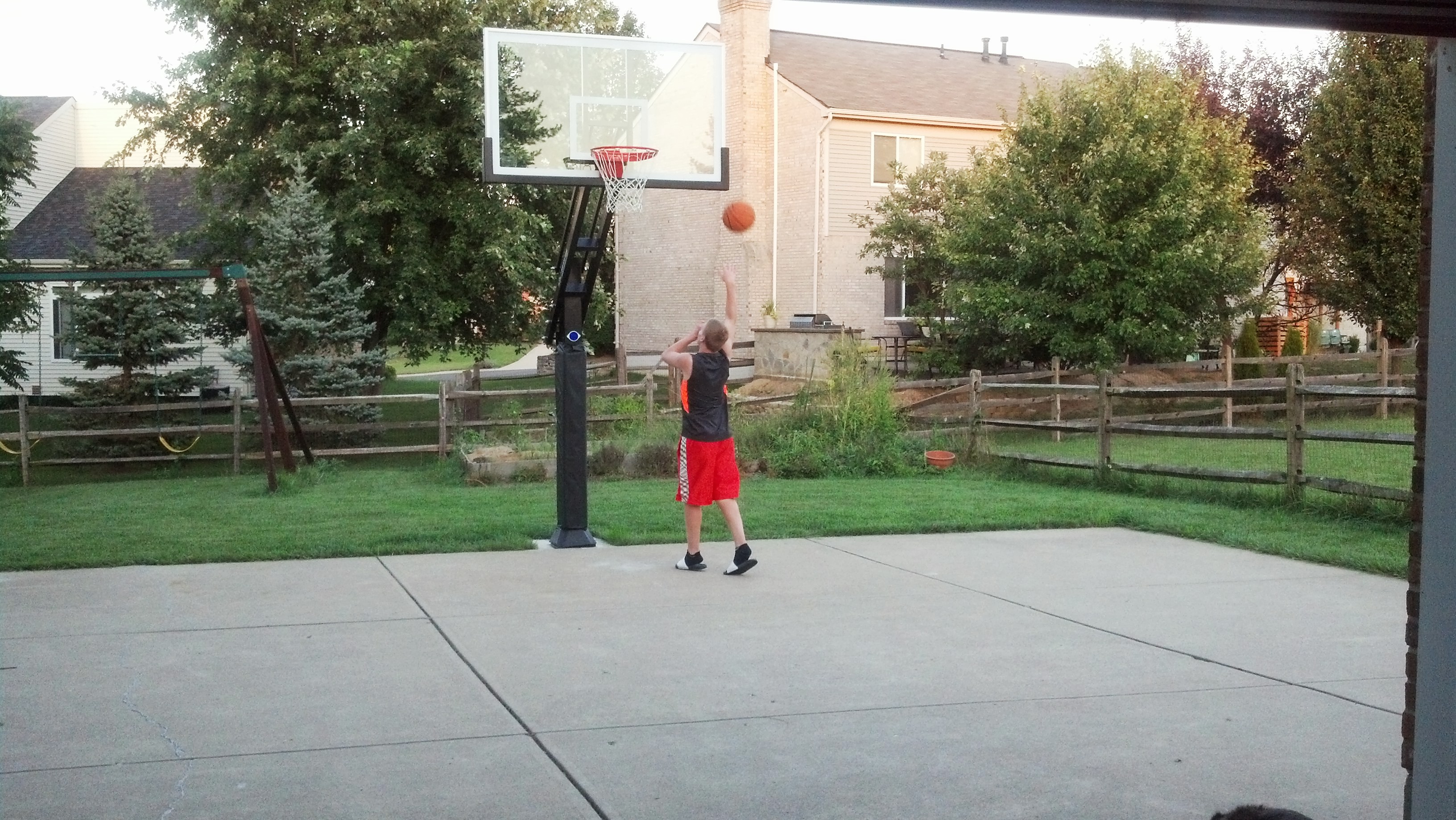 A young man is shooting some hoops in a relaxed way. 