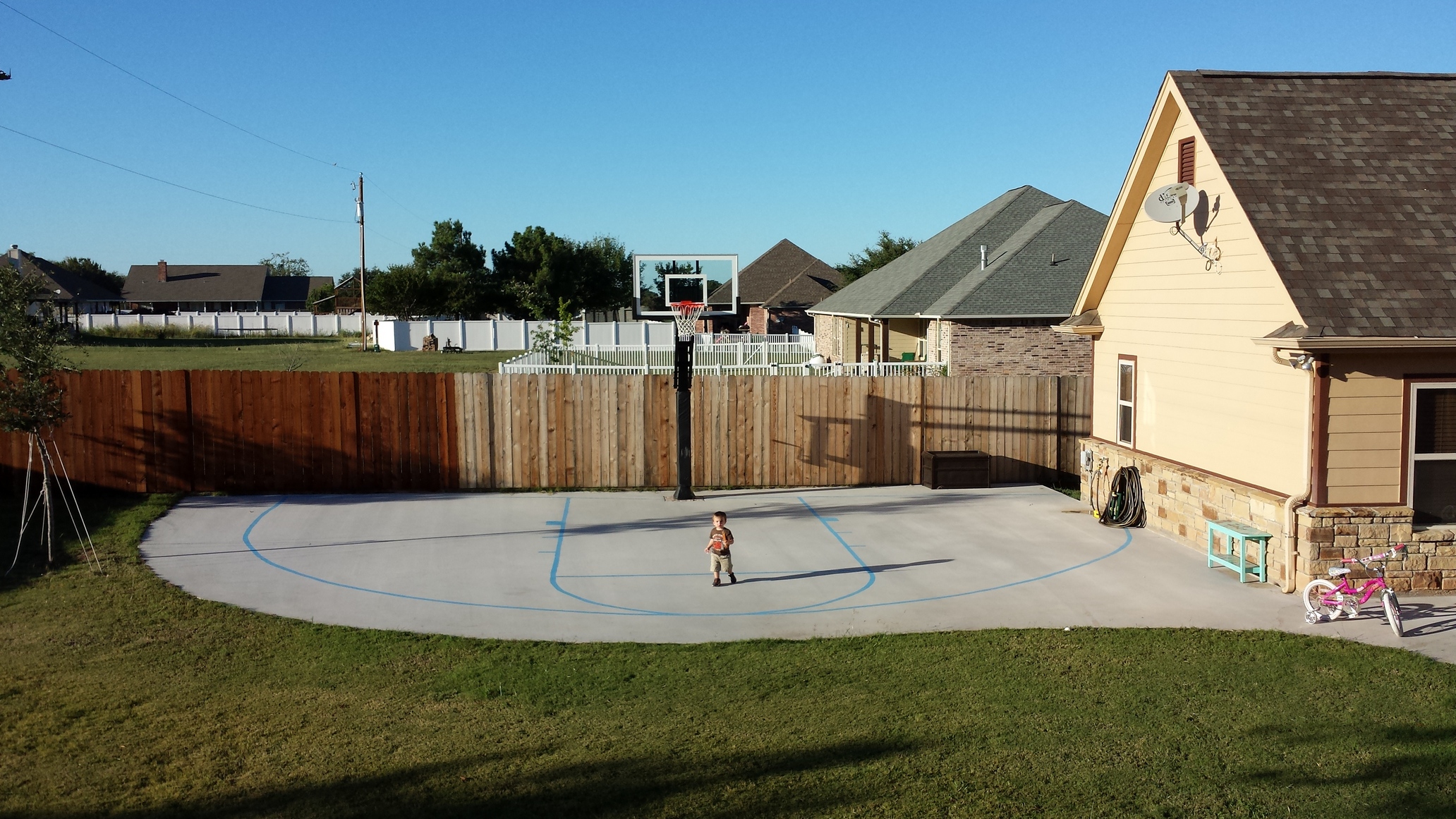 This wide shot shows the full custom court poured for this Pro Dunk Gold Basketball system.