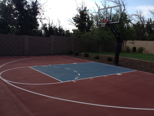 Partially fenced in, this roomy backyard nicely houses a Pro Dunk system for its half court.