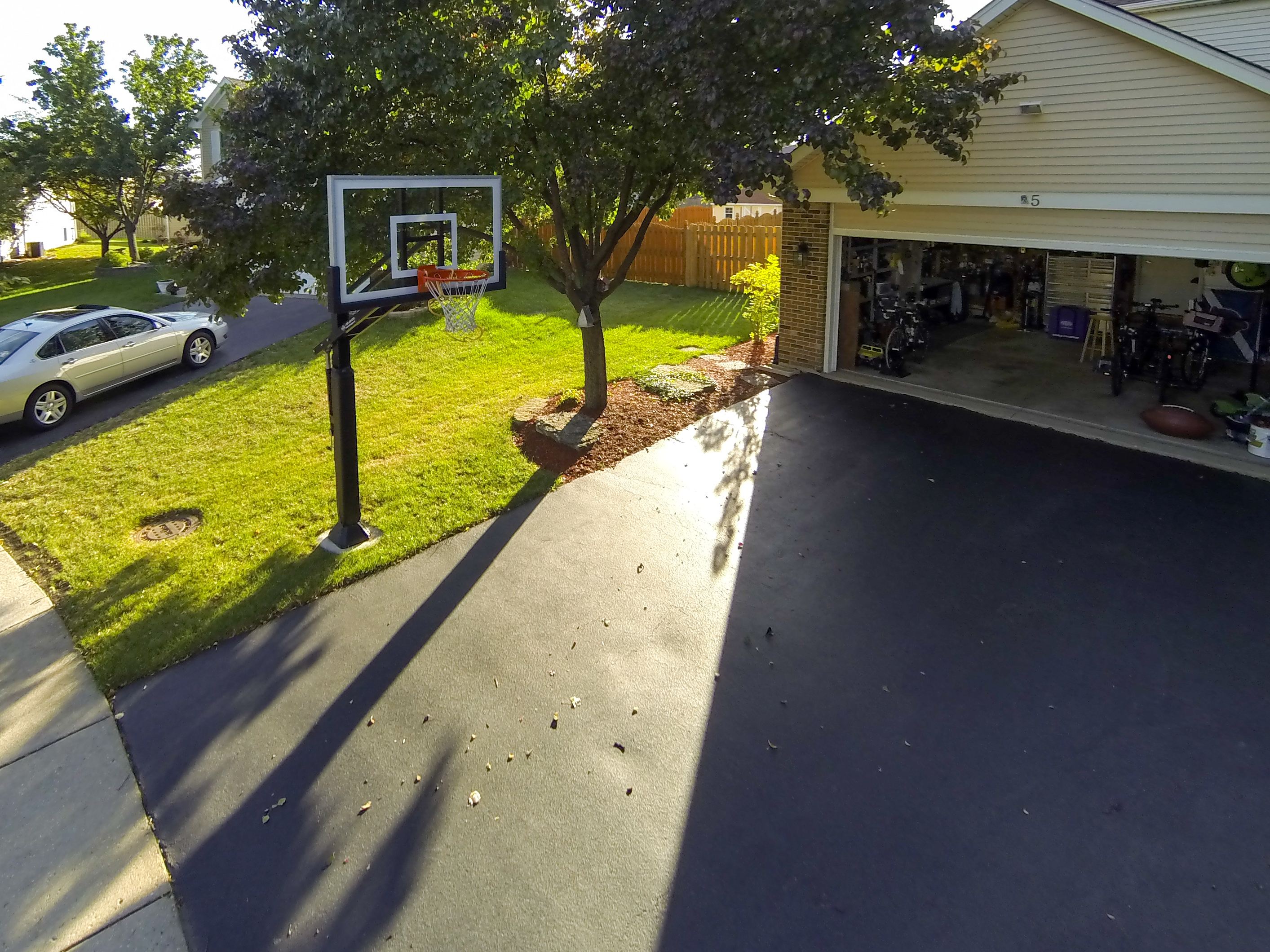 The Pro Dunk Gold sits next to a typical two car garage using the asphalt driveway as great playing area. 