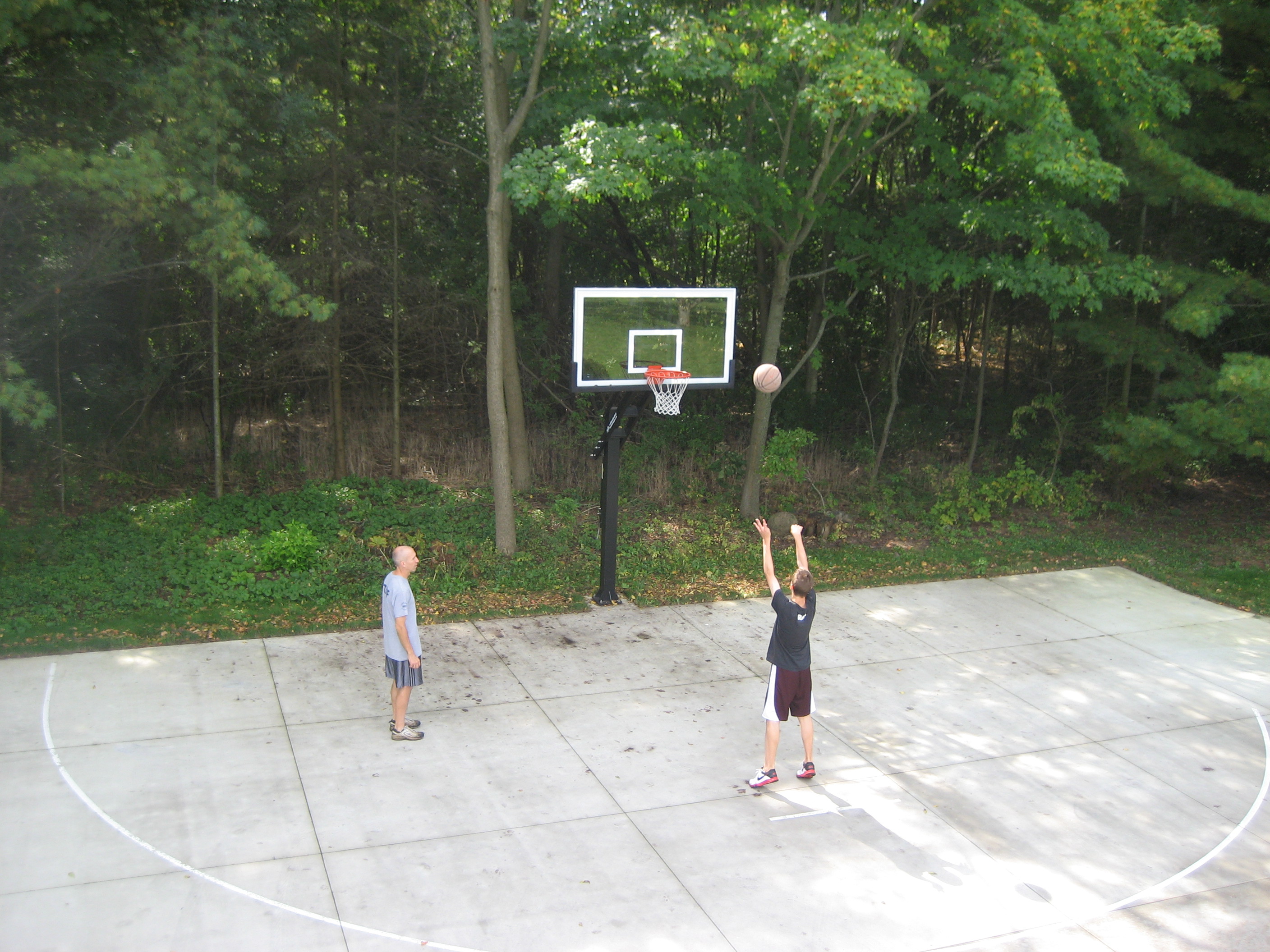This Pro Dunk Platinum basketball goal is surrounded by trees, witnessing greatness in the making. 